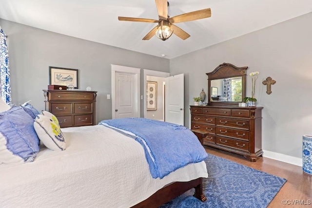 bedroom featuring a ceiling fan, baseboards, and wood finished floors