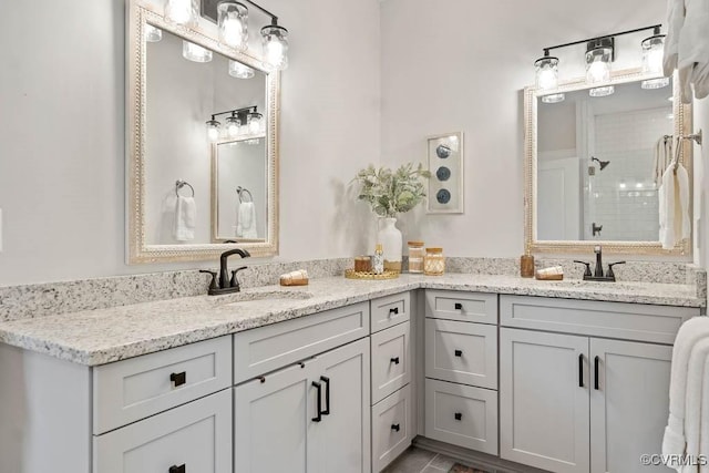 bathroom featuring double vanity, a shower stall, and a sink