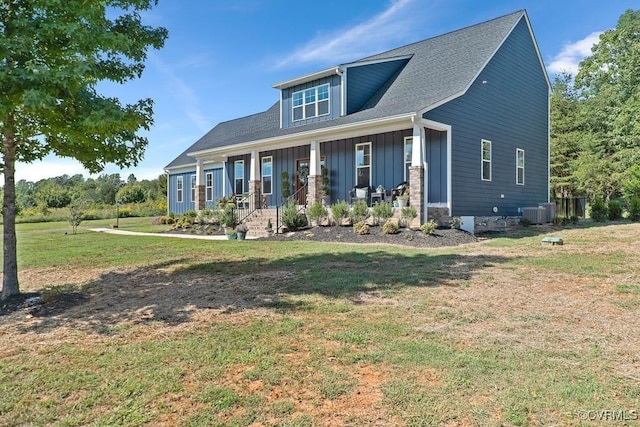 craftsman-style home with a porch, central AC, board and batten siding, and a front lawn