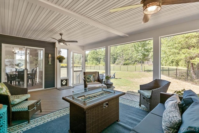 sunroom / solarium with ceiling fan, beam ceiling, and a healthy amount of sunlight