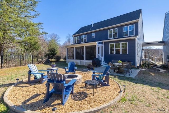 back of house featuring a yard, a sunroom, a patio area, fence, and a fire pit