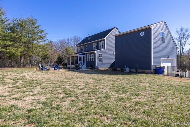 back of property with a lawn, an attached garage, fence, and a sunroom