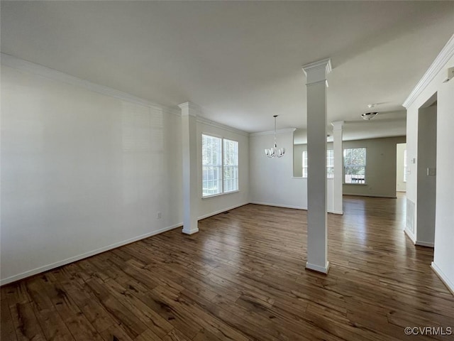 spare room featuring ornamental molding, dark wood-style flooring, a healthy amount of sunlight, and ornate columns