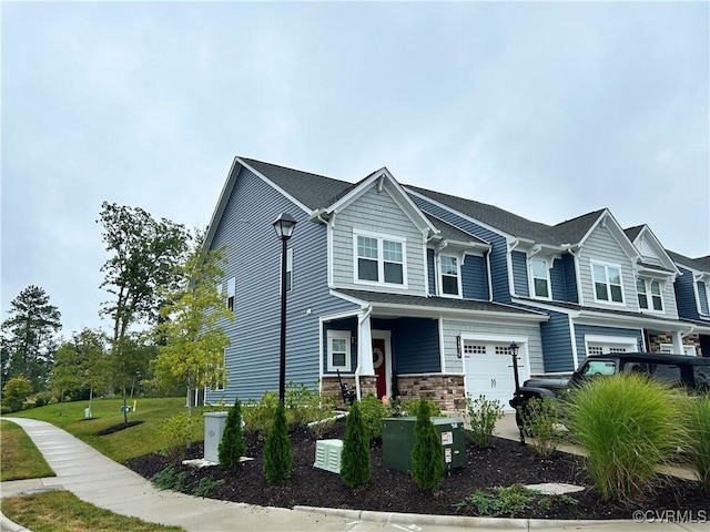 view of front of house with an attached garage, stone siding, and a front yard