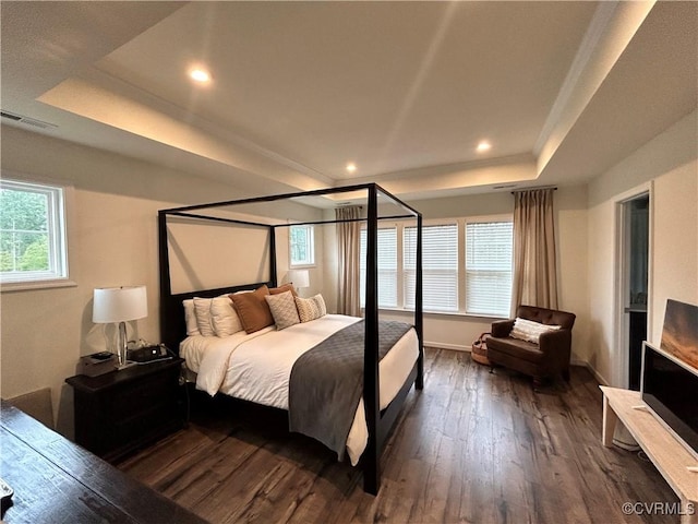 bedroom featuring baseboards, visible vents, a raised ceiling, dark wood-style flooring, and recessed lighting