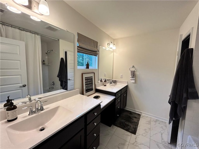 full bath featuring a shower with curtain, marble finish floor, two vanities, and a sink