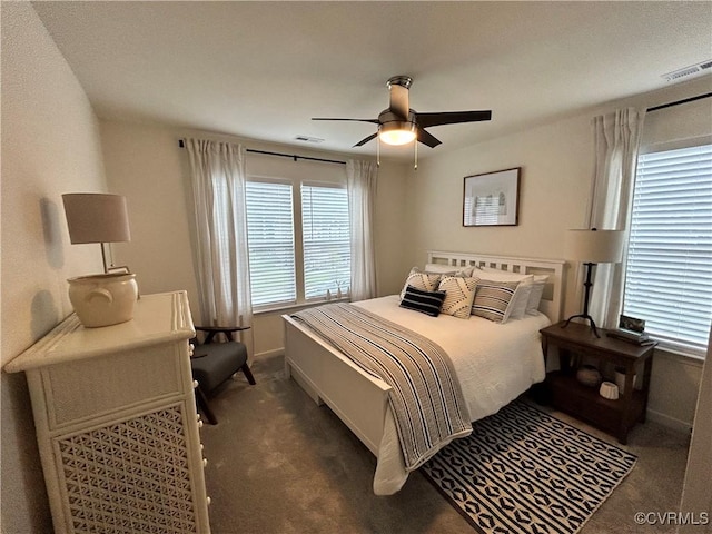 bedroom featuring ceiling fan, visible vents, dark colored carpet, and baseboards