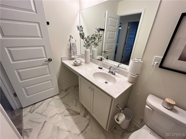 bathroom featuring marble finish floor, baseboards, vanity, and toilet