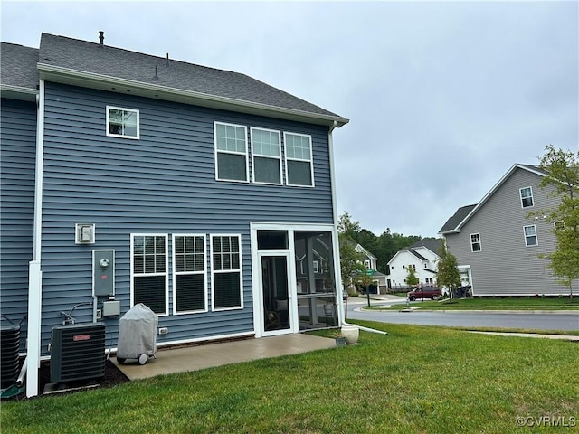 back of property with a sunroom, a lawn, and cooling unit