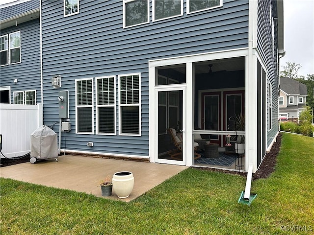 back of property featuring a patio, a lawn, fence, and a sunroom