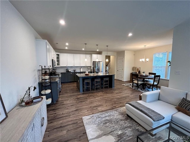 living room featuring a chandelier, recessed lighting, and dark wood-style flooring