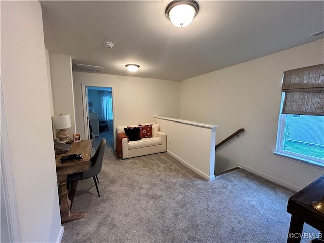 carpeted office space featuring visible vents and baseboards