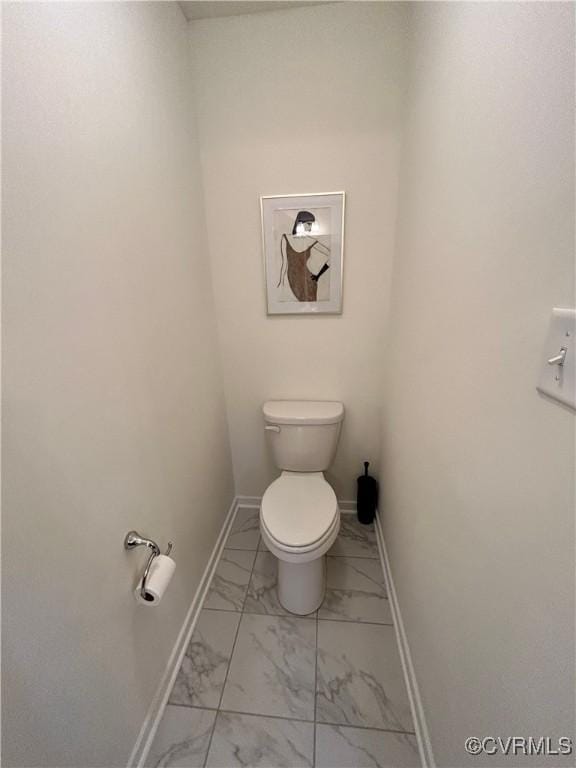 bathroom featuring marble finish floor, toilet, and baseboards