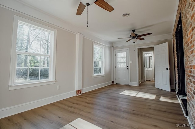 interior space with crown molding, a wealth of natural light, and light hardwood / wood-style flooring