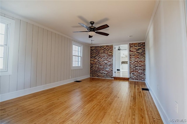 unfurnished room with brick wall, ornamental molding, ceiling fan, and light hardwood / wood-style floors