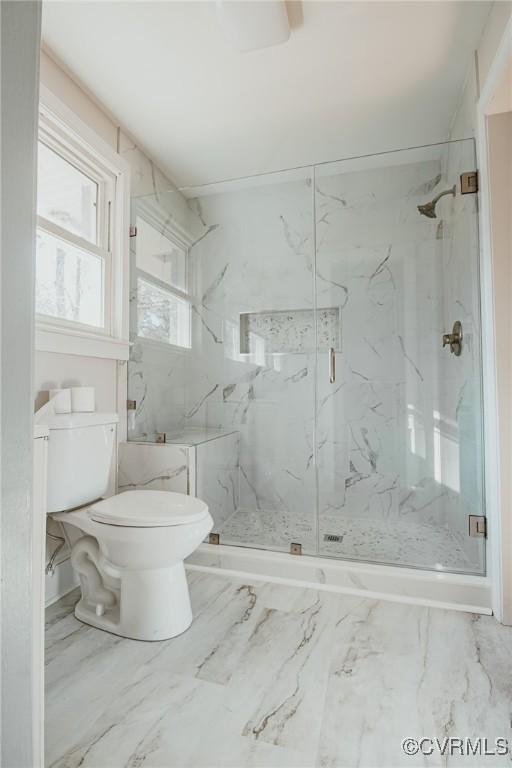 bathroom featuring toilet and an enclosed shower