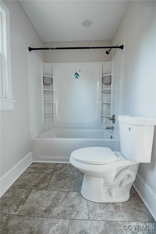 bathroom featuring shower / tub combination and toilet