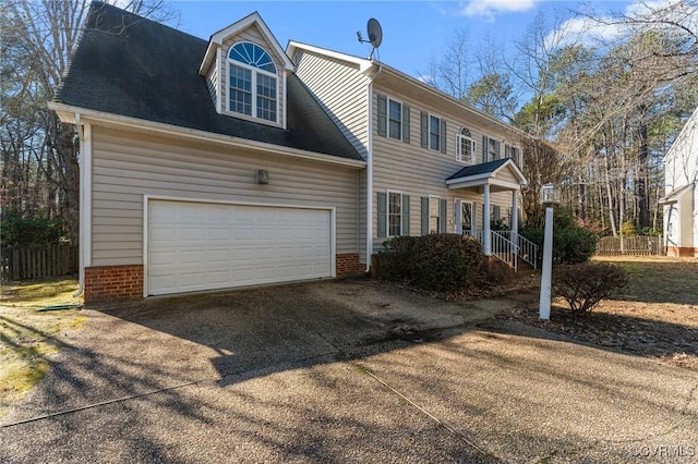 view of front of property with roof with shingles, driveway, and an attached garage