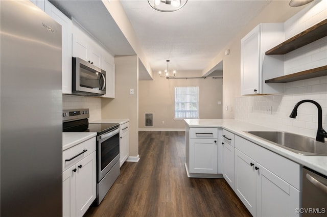 kitchen with white cabinets, a peninsula, and stainless steel appliances