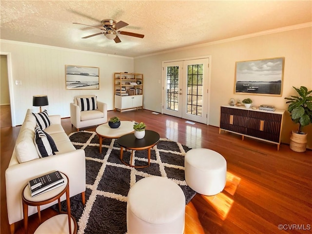 living room featuring french doors, a textured ceiling, and ornamental molding