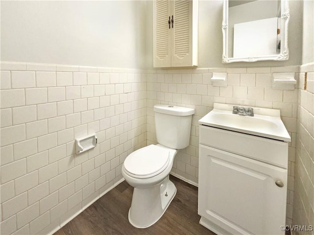 bathroom with tile walls, toilet, hardwood / wood-style flooring, and vanity