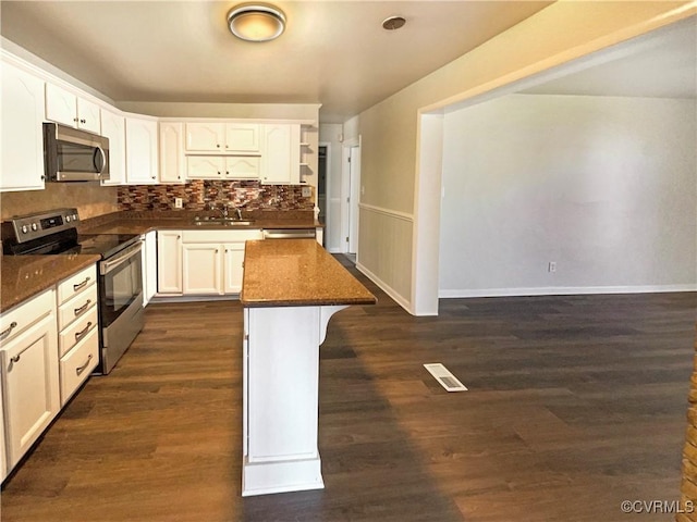 kitchen with dark stone counters, sink, white cabinetry, and stainless steel appliances