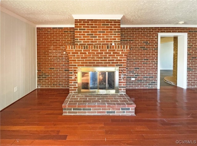 unfurnished living room featuring a fireplace, crown molding, a textured ceiling, and dark hardwood / wood-style floors