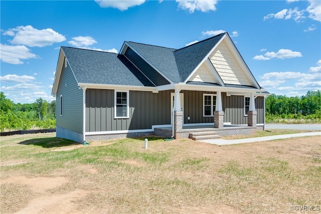 view of front of home featuring covered porch, board and batten siding, and roof with shingles