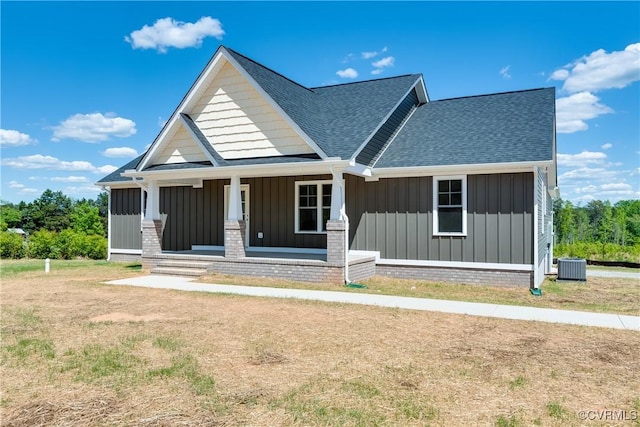 view of front of home with a shingled roof, central AC, a porch, and board and batten siding