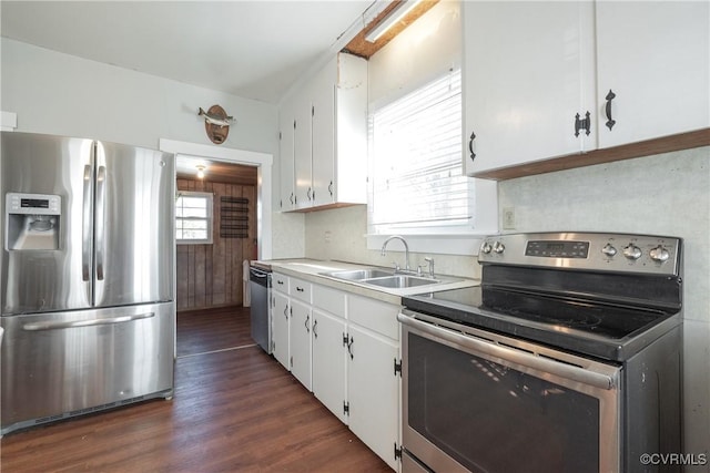 kitchen with appliances with stainless steel finishes, tasteful backsplash, dark hardwood / wood-style flooring, sink, and white cabinetry