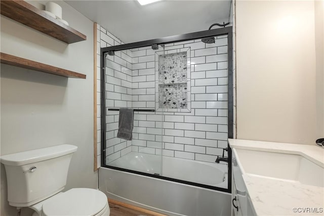 full bathroom featuring enclosed tub / shower combo, vanity, and toilet