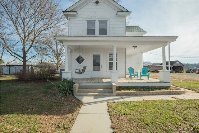 view of front of property with covered porch and a front yard