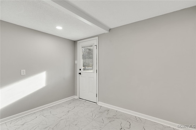 unfurnished room with a textured ceiling