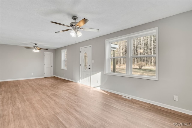 unfurnished living room with light wood-type flooring, a textured ceiling, and ceiling fan