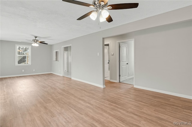 empty room featuring light wood-type flooring, a textured ceiling, and ceiling fan