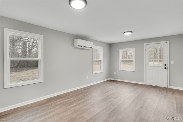 interior space featuring a wall unit AC and light hardwood / wood-style floors