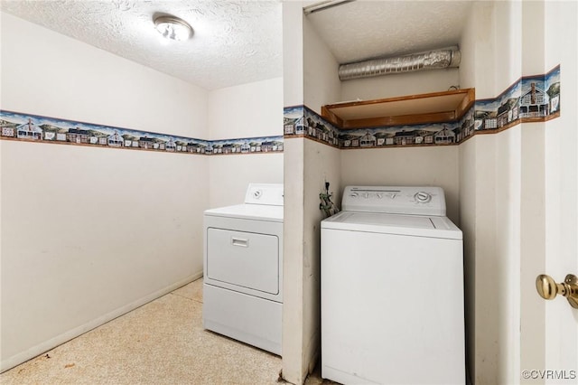 washroom featuring washing machine and dryer and a textured ceiling