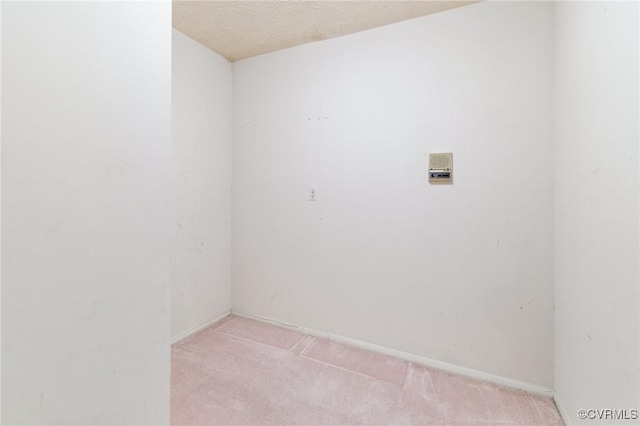 empty room featuring light carpet and a textured ceiling