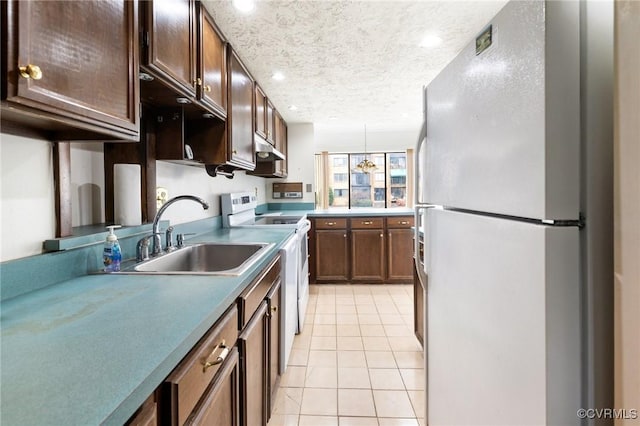 kitchen with electric stove, a textured ceiling, light tile patterned floors, sink, and fridge