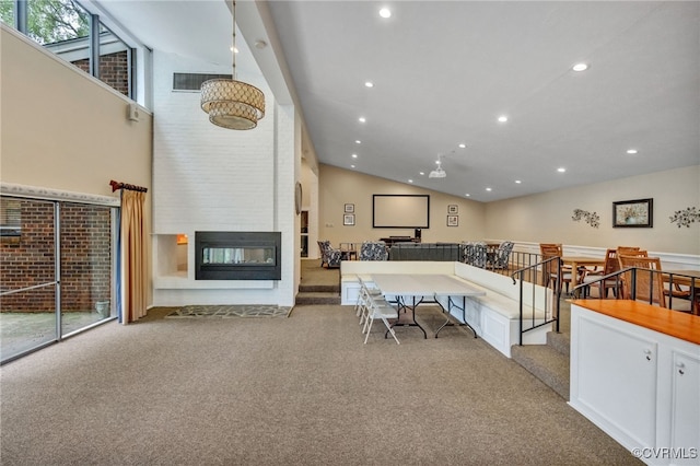 interior space featuring light carpet, high vaulted ceiling, and a fireplace