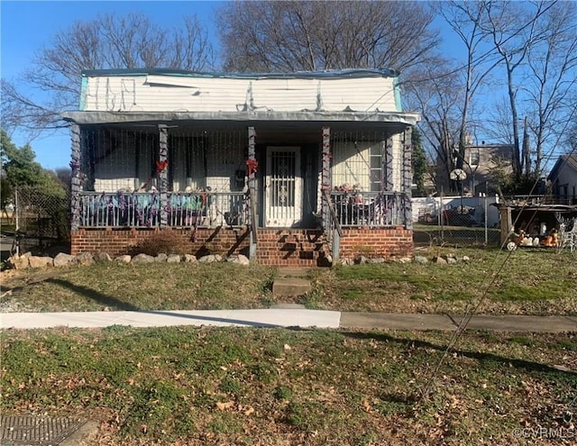 view of front of house featuring covered porch and a front lawn