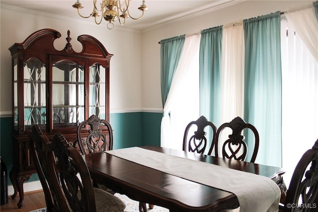 dining space with ornamental molding and a chandelier