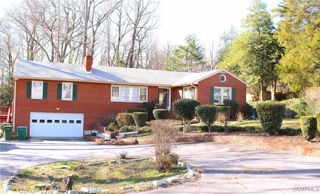 ranch-style house with a garage, brick siding, a chimney, and driveway