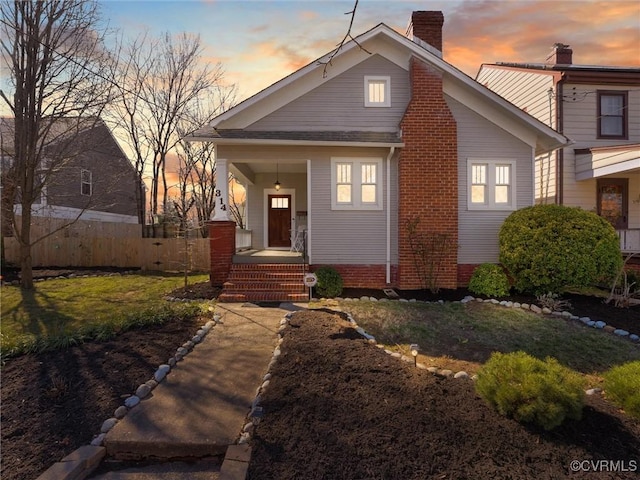 view of front facade with covered porch and a lawn