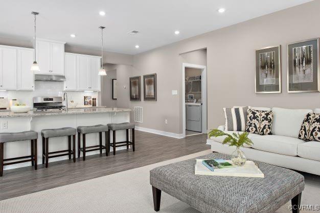 living room with dark hardwood / wood-style flooring and washer / dryer