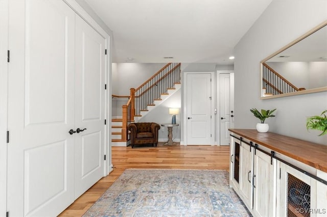 foyer featuring light wood-style flooring, recessed lighting, and stairway