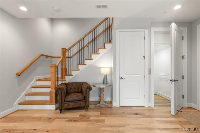 staircase featuring baseboards, visible vents, wood finished floors, and recessed lighting