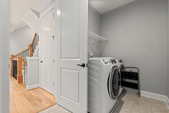 washroom featuring baseboards, laundry area, light tile patterned floors, and washer and dryer