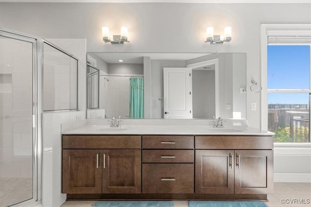 bathroom featuring double vanity, a stall shower, and a sink