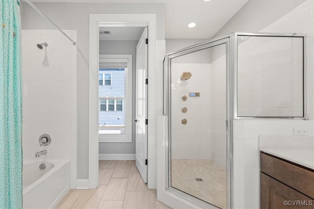 bathroom featuring a tub to relax in, a stall shower, vanity, and baseboards